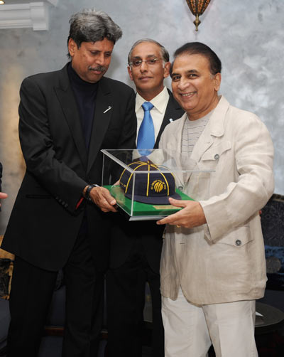 Former Indian cricketer Sunil Gavaskar (R) is presented with his ICC Hall of Fame cap by Kapil Dev (2nd L) and ICC Chief Executive Haroon Lorgat
