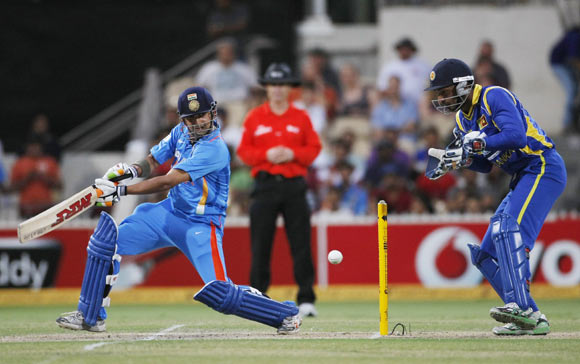 Gautam Gambhir (L) plays a shot as wicket keeper Kumar Sangakkara looks on