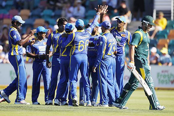 Sri Lankan players celebrate the dismissal of Forrest (right) as he walks of the field