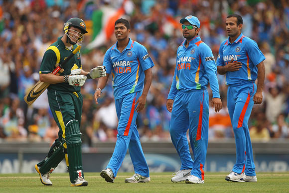 David Hussey of Australia walks after the field after being dismissed by Umesh Yadav of India (L) during the One Day International match