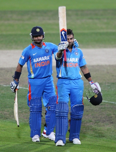 Kohli gets a pat from Suresh Raina after completing a hundred