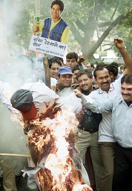 Supporters burn an effigy of match referee Mike Denness, as others hold a poster of national cricket icon Sachin