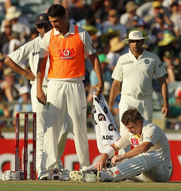 Warner regains his composure after being hit by a bouncer from Umesh Yadav