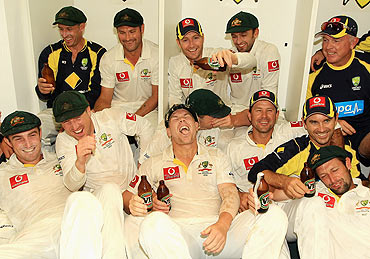 David Warner (front) of Australia has beer poured on him by captain Michael Clarke as the team celebrate their win in the dressing room on Sunday
