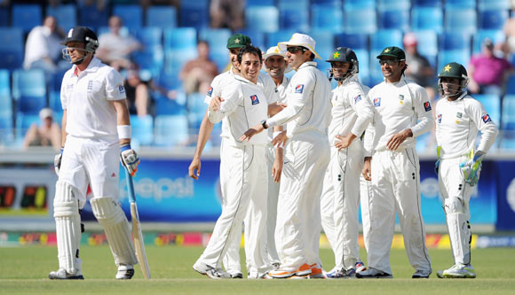 Saeed Ajmal of Pakistan celebrates with teammates after dismissing Ian Bell (L) of England during the first Test match