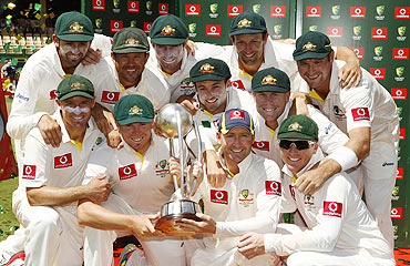 The Australian team pose with the Border-Gavaskar Trophy