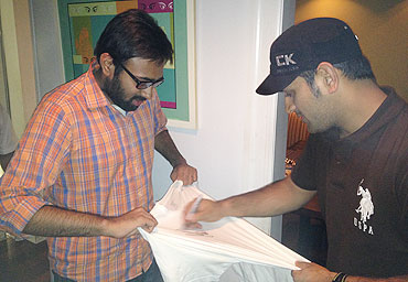MS Dhoni autographs a T-shirt for a fan