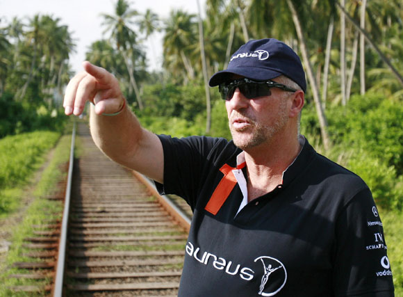 Former England cricket player Ian Botham gestures next to the train tracks as he talks about the train that was pushed off the tracks by the December 2004 tsunami
