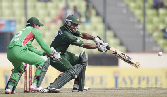 Pakistan's Mohammad Hafeez (R) plays a shot as Bangladesh's captain and wicket keeper Mushfiqur Rahim (L) looks on