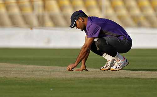 India's captain Mahendra Singh Dhoni inspects the pitch during a cricket practice session