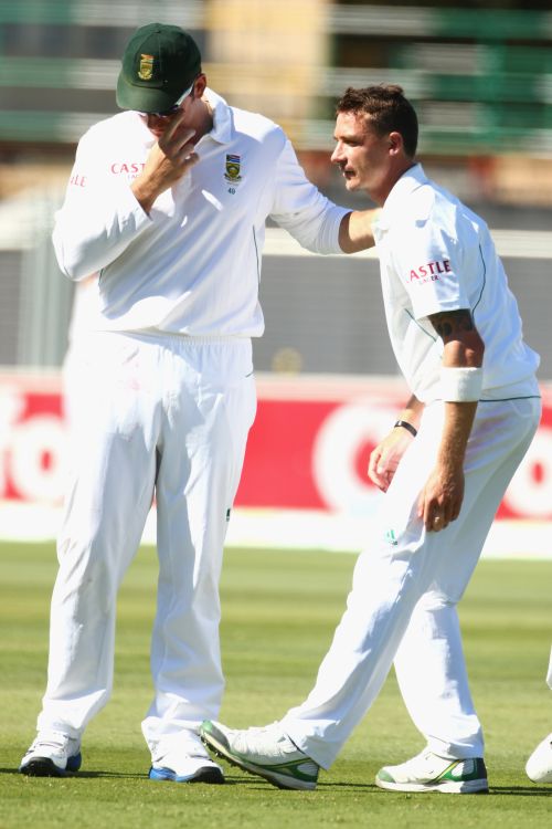 Graeme Smith of South Africa speaks to Dale Steyn of South Africa as he stretches his hamstring