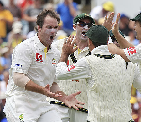 Australia's John Hastings (left) celebrates with teammates after picking his first Test wicket on dismissing South Africa's AB de Villiers on Day 1 of the third Test at the WACA