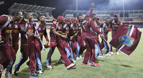 West Indies' Marlon Samuels waves a flag as his teammates watch