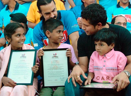 Sachin Tendulkar (right) speaks with children as Bollywood actor Aamir Khan (centre) looks on, in Mumbai