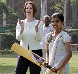 Australian Prime Minister Julia Gillard applauds as girls play cricket during a clinic in New Delhi