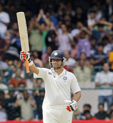 India's Suresh Raina raises his bat to celebrate scoring 50 runs