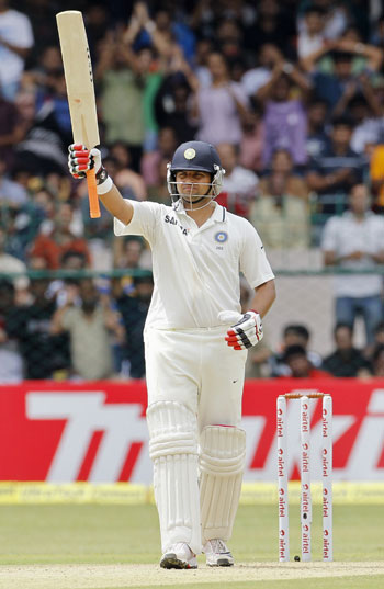 India's Suresh Raina raises his bat to celebrate scoring 50 runs