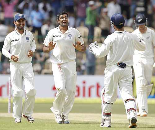 India's R Ashwin celebrates with teammates after dismissing New Zealand's Daniel Flynn during the third day of their second Test match in Bangalore