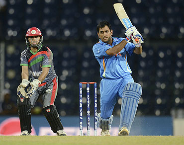 India's Mahendra Singh Dhoni plays a shot as Afghanistan's Karim Sadiq (left) watches