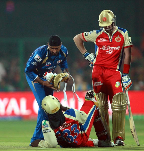 Harbhajan Singh attends to the injured Chris Gayle after the two players collided