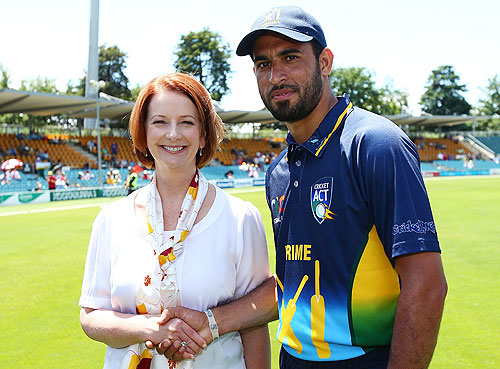 Australian Prime Minister Julia Gillard greats Fawad Ahmed a former Pakistani asylum seeker before the International Tour Match between the Prime Minister's XI and West Indies at Manuka Oval on January 29, 2013 in Canberra, Australia