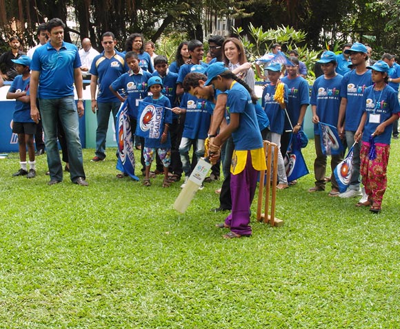 Sachin Tendulkar teaches a young girl to grip the bat