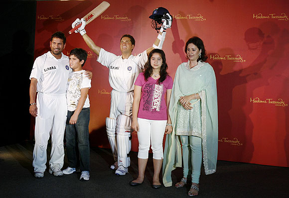 Indian cricketer Sachin Tendulkar (left), his son Arjun, daughter Sara and wife Anjali (right) pose with Sachin's new wax statue at Madame Tussauds museum, in London, on April 13, 2009