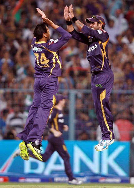 Sunil Narine celebrates with team mate Manoj Tiwary after getting the wicket of Dwayne Smith