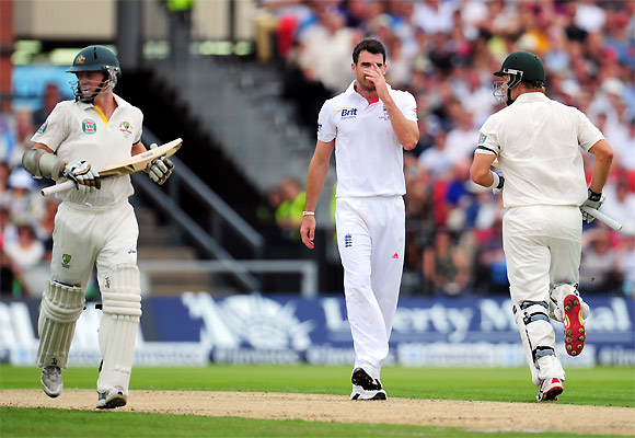 James Anderson reacts as Chris Rogers (left) and Shane Watson run between the wickets