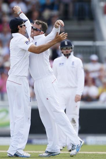 England's Graeme Swann (centre) celebrates with captain   Alastair Cook (left) after taking the wicket of Australia's Peter Siddle
