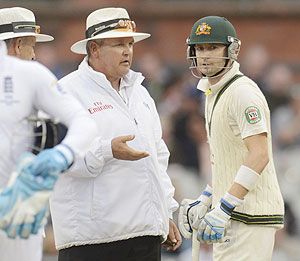Australia's captain Michael Clarke speaks to umpire Marais Erasmus on the field after they sent the teams off for bad light on Sunday