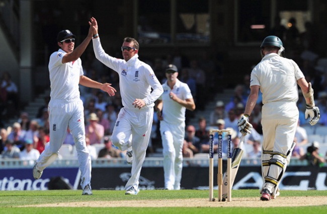 Graeme Swann of England celebrates the wicket of Chris Rogers of Australia with Alastair Cook (left)