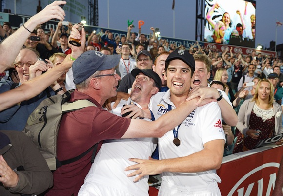 Kevin Pietersen and Alastair Cook of England celebrate with fans