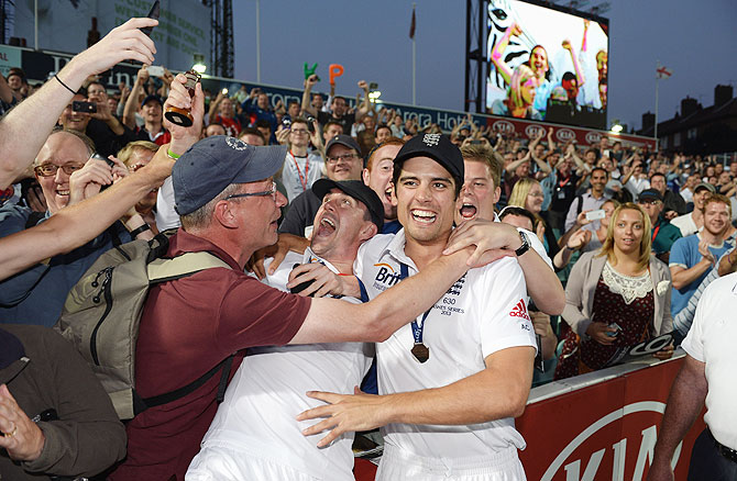 Kevin Pietersen and Alastair Cook of England celebrate with fans after England won the Ashes on Sunday