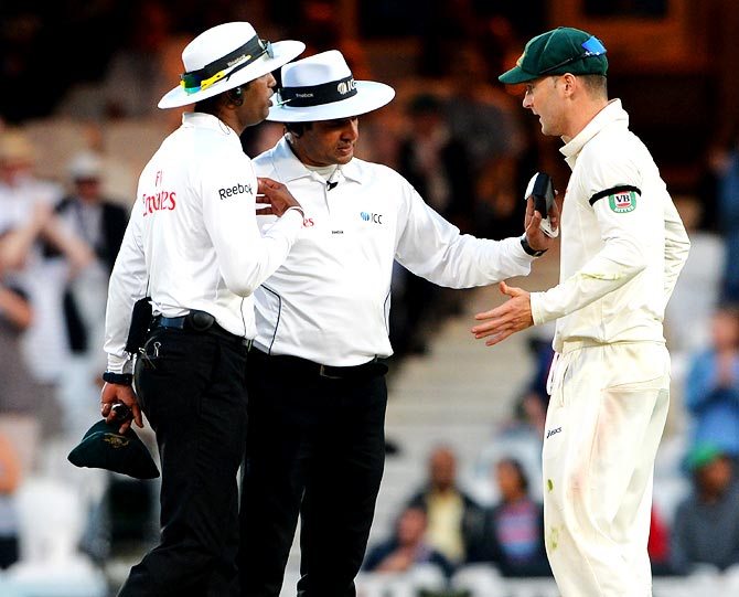 Australia captain Michael Clarke (right) speaks to umpires Aleem Dar and Kumar Dharmasena