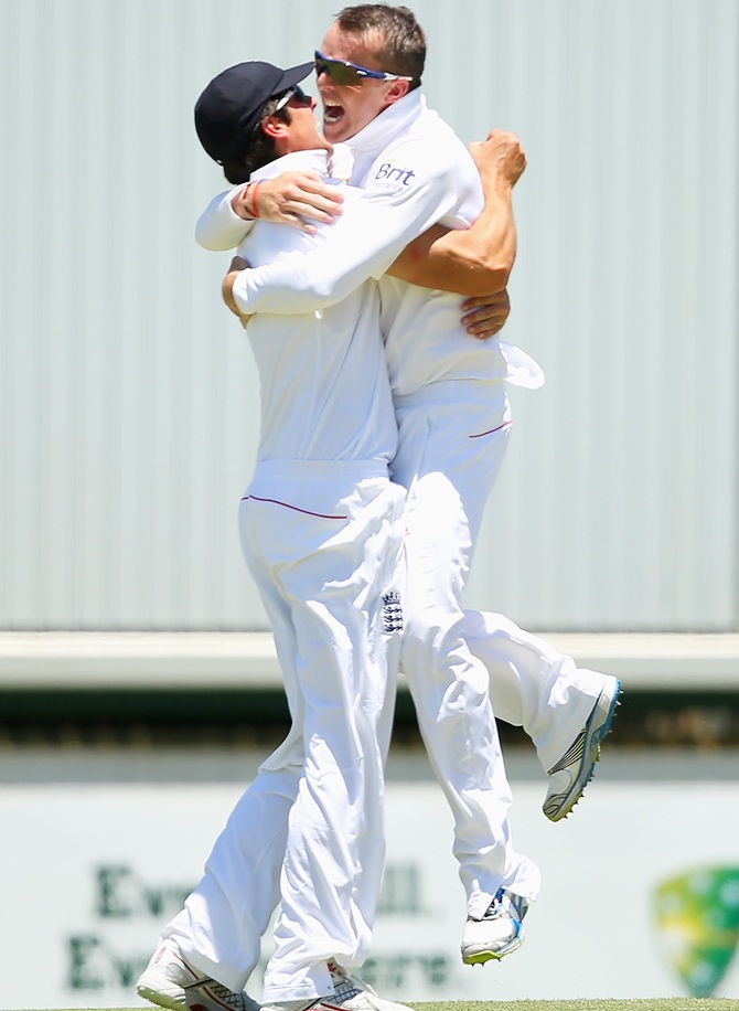 Graeme Swann of England hugs Alastair Cook after catching Michael Clarke of Australia