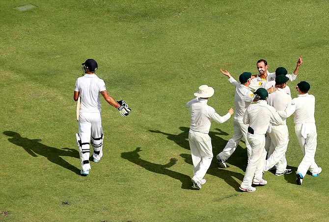 Australia's players celebrate as Kevin Pietersen walks back after his dismissal