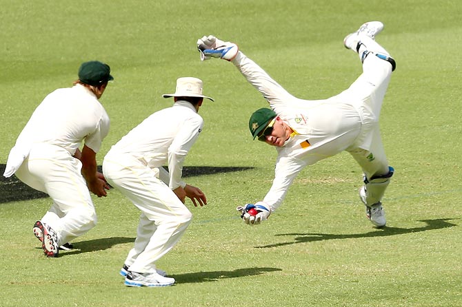 Australia wicketkeeper Brad Haddin (right) takes a catch to dismiss Joe Root