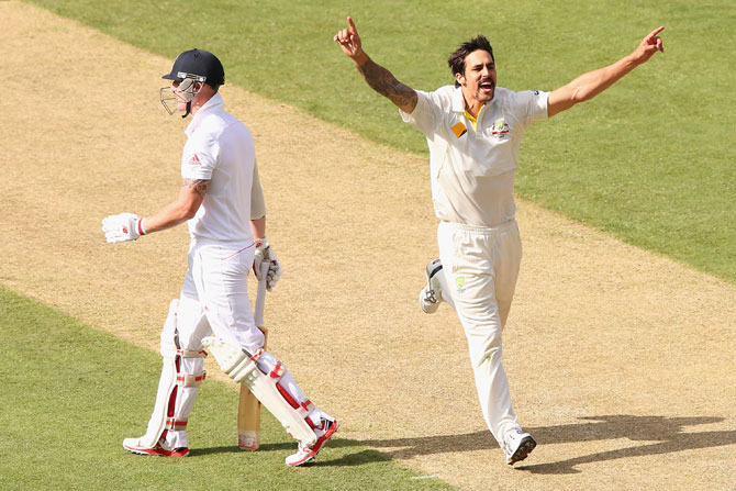 Mitchell Johnson of Australia celebrates taking the wicket of Ben Stokes of England