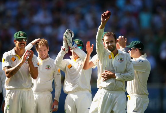 Nathan Lyon of Australia raises the ball after taking his fifth wicket 