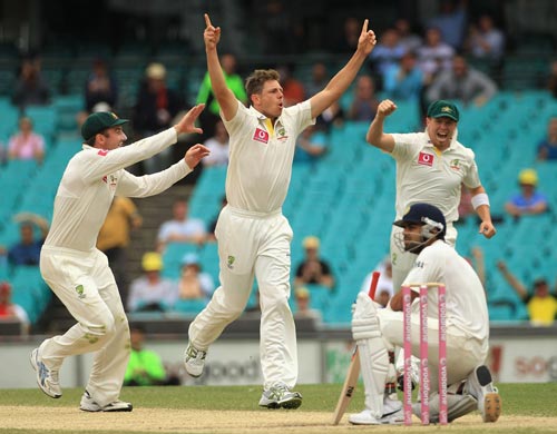 James Pattinson of Australia celebrates with team mates Shaun Marsh (L) and David Warner (R) after taking the wicket of Virat Kohli