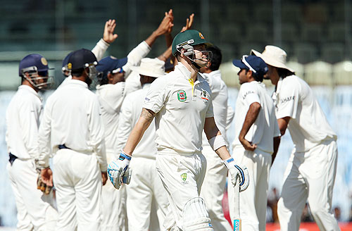 Indians celebrate as Australia captain Michael Clarke walks off after his dismissal