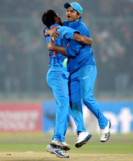 Shami Ahmed (left) celebrates with Suresh Raina after getting the wicket of Saeed Ajmal