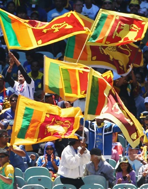 Fans wave the Sri Lanka flag during a cricket match