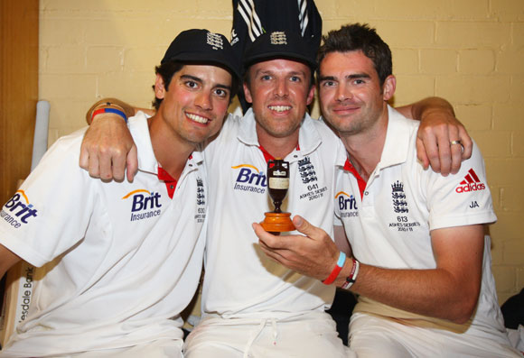 Alastair Cook, Graeme Swann and James Anderson of England celebrate in the dressing room with the ashes urn after winning the series 3-1