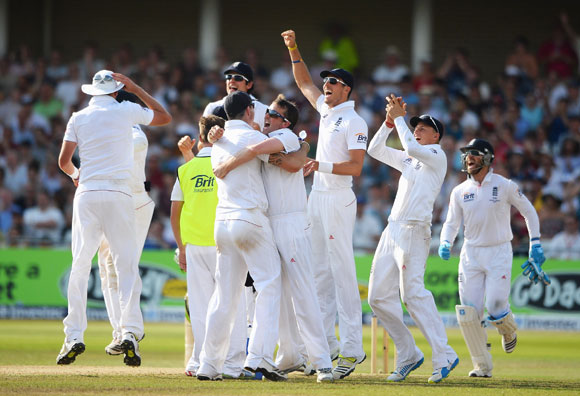 Graeme Swann of England celebrates the wicket of Phil Hughes of Australia with team mates