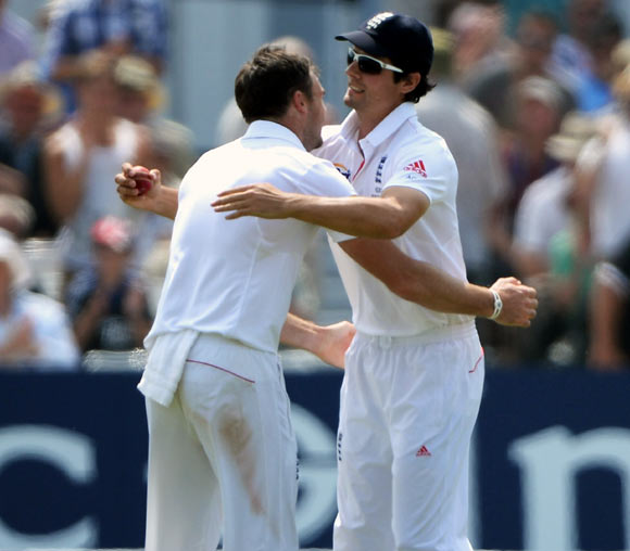 England captain Alastair Cook celebrates after taking the catch to dismiss Mitchell Starc with bowler James Anderson