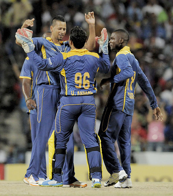 Rayad Emrit and Umar Akmal of Barbados Tridents celebrate the wicket of St. Lucia Zouks' Herschelle Gibbs at Kensington Oval in Bridgetown, Barbados, on Tuesday