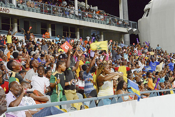 Fans cheer their team during the opening match of the Cricket Caribbean Premier League between Barbados Tridents and St Lucia Zouks at Kengsinton Oval in Bridgetown, Barbados, on Tuesday