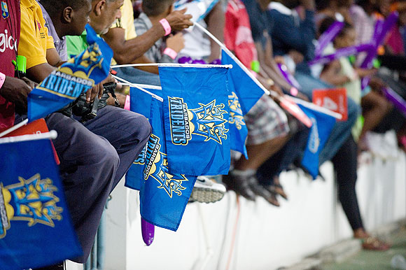 Barbados Tridents fans wave their flags during the opening match of the Cricket Caribbean Premier League between Barbados Tridents and St Lucia Zouks at Kengsinton Oval in Bridgetown, Barbados, on Tuesday